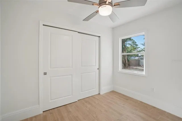 an empty room with fan and windows