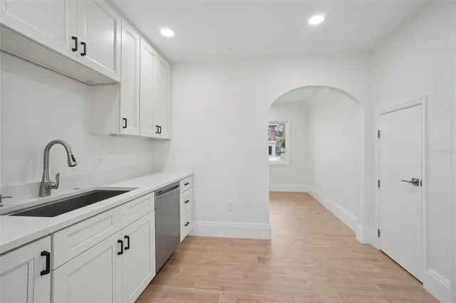 a open kitchen with white cabinets and sink
