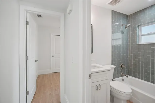 a bathroom with a granite countertop toilet a sink and a shower