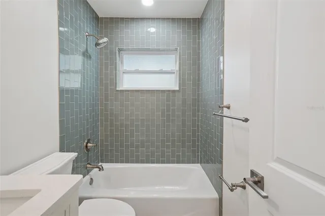 a bathroom with a bathtub shower sink vanity and toilet