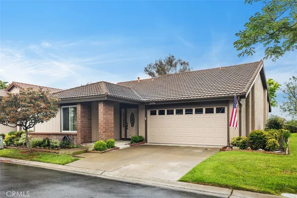 a front view of a house with a garden and garage