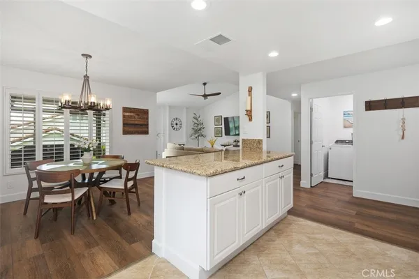 a kitchen with a table chairs and white cabinets