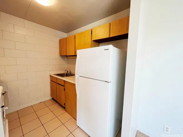 a white refrigerator freezer and a stove sitting inside of a kitchen
