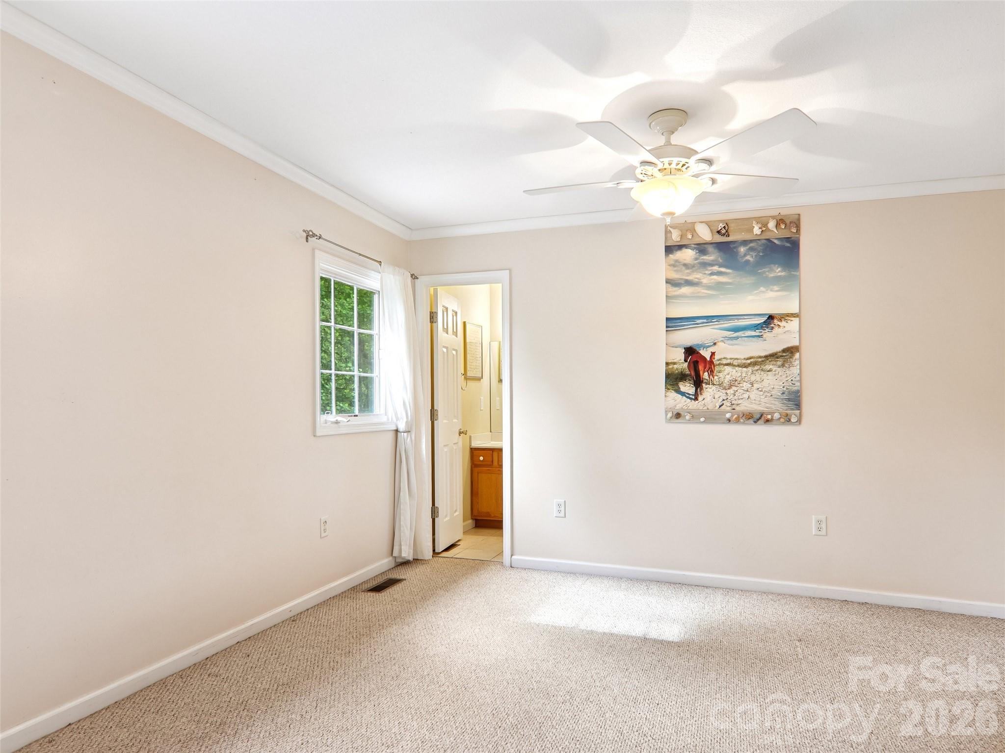 34 Union Chapel Road, Unit 7 Weaverville, NC 28787 - Photo 26 of 37 an empty room with a chandelier fan and windows