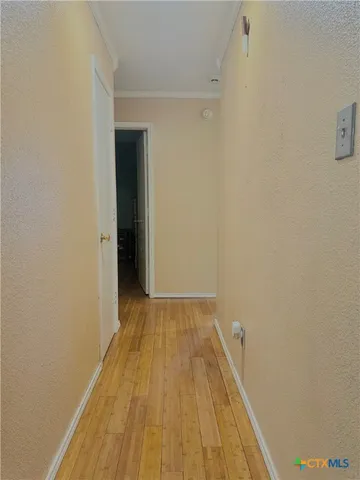 a view of a room with wooden floor and a ceiling fan