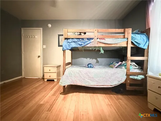 a bedroom with a bed and wooden floor