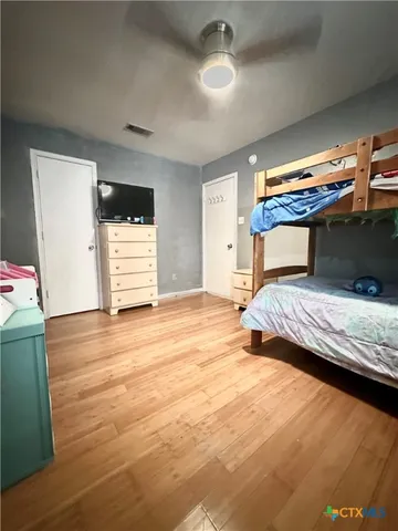 a bedroom with a bed and wooden floor