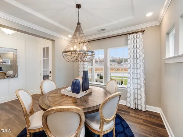a dining room with furniture a chandelier and wooden floor