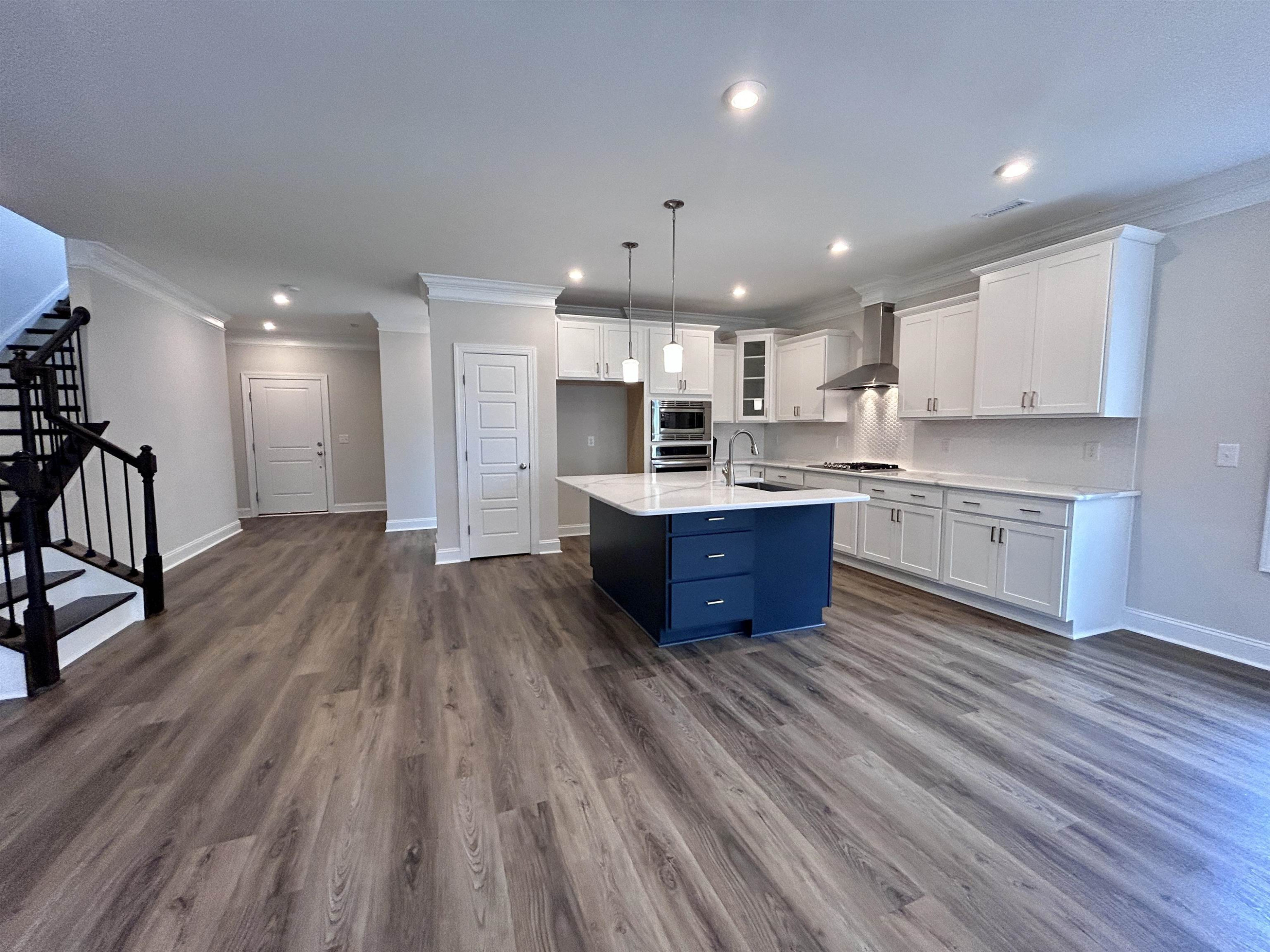 208 Kavanaugh Road Wake Forest, NC 27587 - Photo 2 of 23 a open kitchen with kitchen island wooden floors granite counter tops and white cabinets
