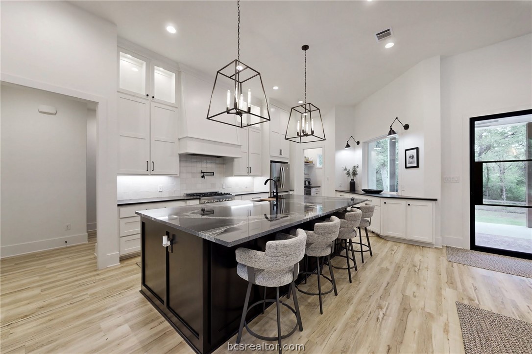 1629 Sawmill Road Franklin, TX 77856 - Photo 7 of 47 a kitchen with granite countertop a table chairs and wooden floor