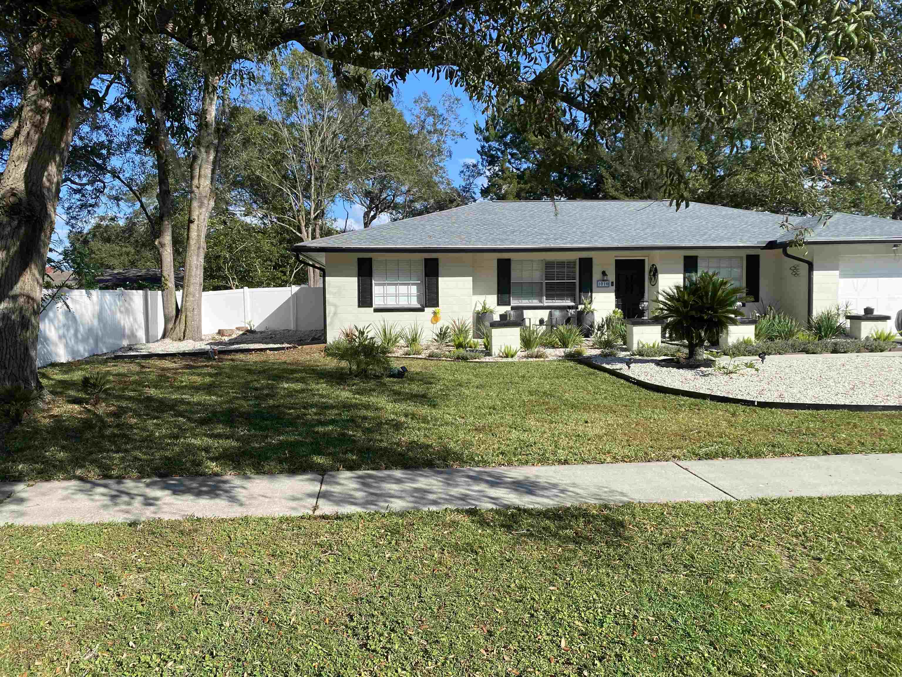 a front view of a house with a garden and yard