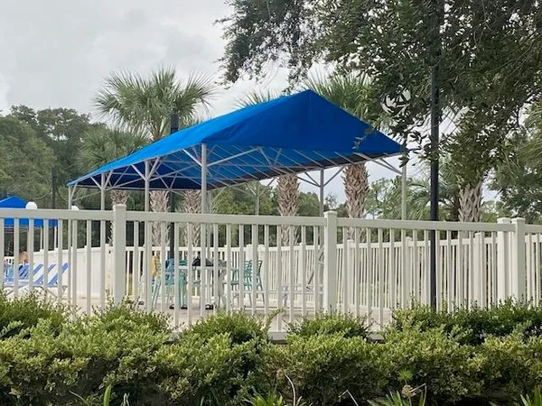 a view of a patio with table and chairs under an umbrella