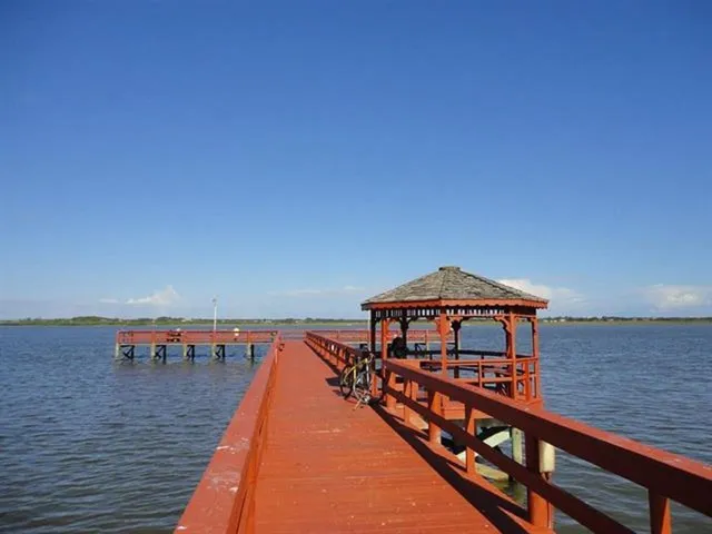 a view of a deck with a small yard and wooden fence
