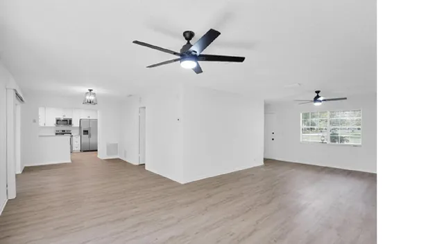 a view of a livingroom with a ceiling fan and wooden floor