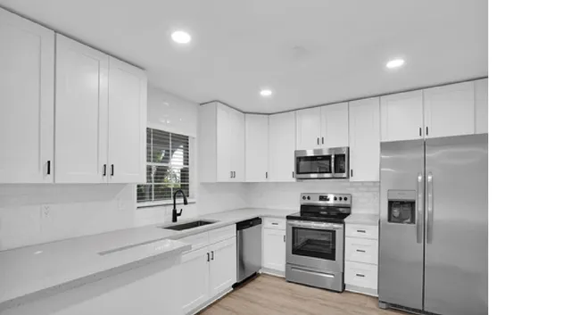 a kitchen with stainless steel appliances granite countertop a refrigerator sink and stove