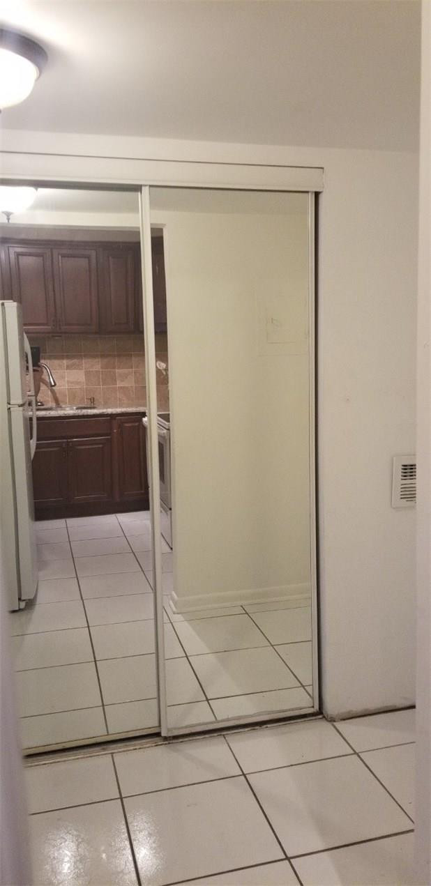 255 South Cypress Road, Unit 301 Pompano Beach, FL 33060 - Photo 9 of 42 a view of a refrigerator in kitchen and an empty room