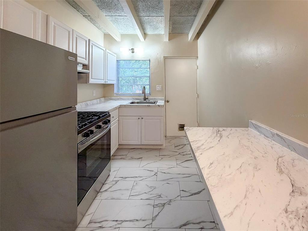 219 Northwest 3rd Avenue, Unit B Gainesville, FL 32601 - Photo 6 of 20 a kitchen with granite countertop a refrigerator and a stove