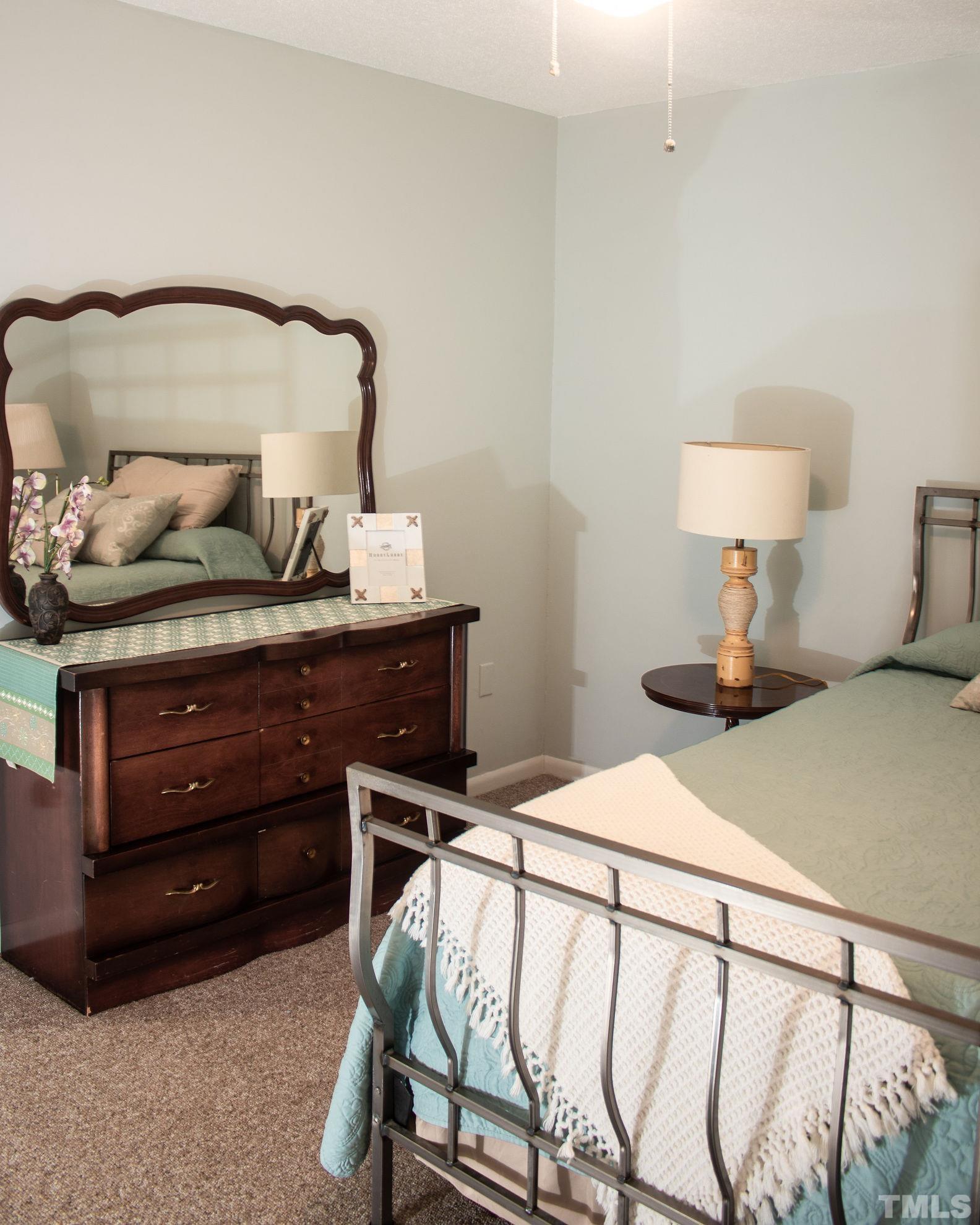 70 Waters Edge Loop Henderson, NC 27537 - Photo 27 of 49 a bedroom with a bed and a lamp on table