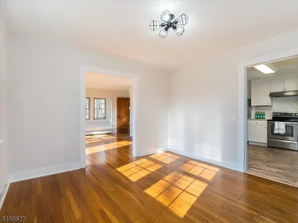 a view of a room with wooden floor and a kitchen