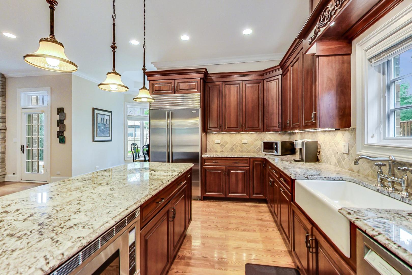 827 South Chester Avenue Park Ridge, IL 60068 - Photo 8 of 38 a kitchen with kitchen island granite countertop a sink and a wooden floor