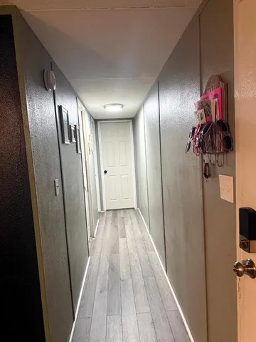 a view of a hallway with wooden floor