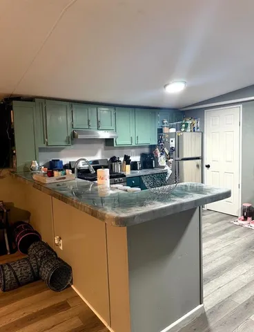 a kitchen with stainless steel appliances granite countertop a sink stove and cabinets