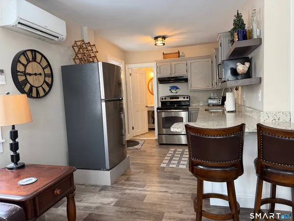 a kitchen with stainless steel appliances granite countertop a refrigerator a stove a sink and a dining table with garden view