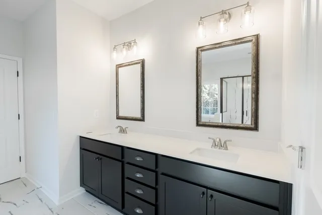 a bathroom with double sink and two mirror