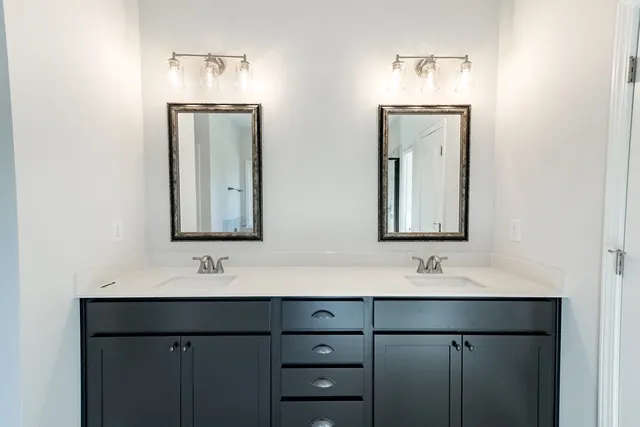 a bathroom with double vanity sinks and a mirror