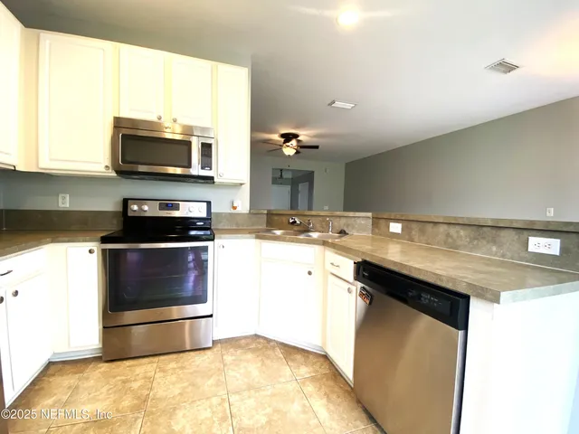a kitchen with a sink and a stove top oven with wooden floor