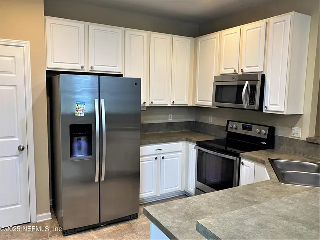 a kitchen with stainless steel appliances granite countertop a refrigerator stove and microwave