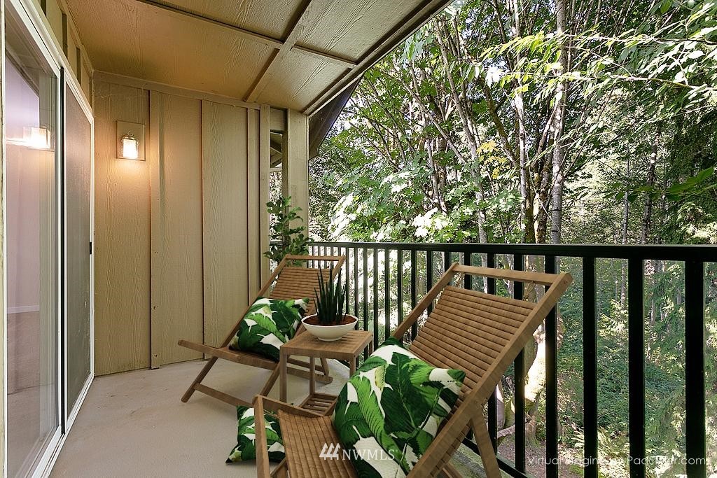18930 Bothell Everett Highway, Unit C303 Bothell, WA 98012 - Photo 11 of 12 a balcony with wooden floor outdoor seating and furniture