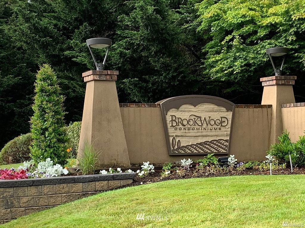 18930 Bothell Everett Highway, Unit C303 Bothell, WA 98012 - Photo 2 of 12 a sign that is sitting on a wooden fence