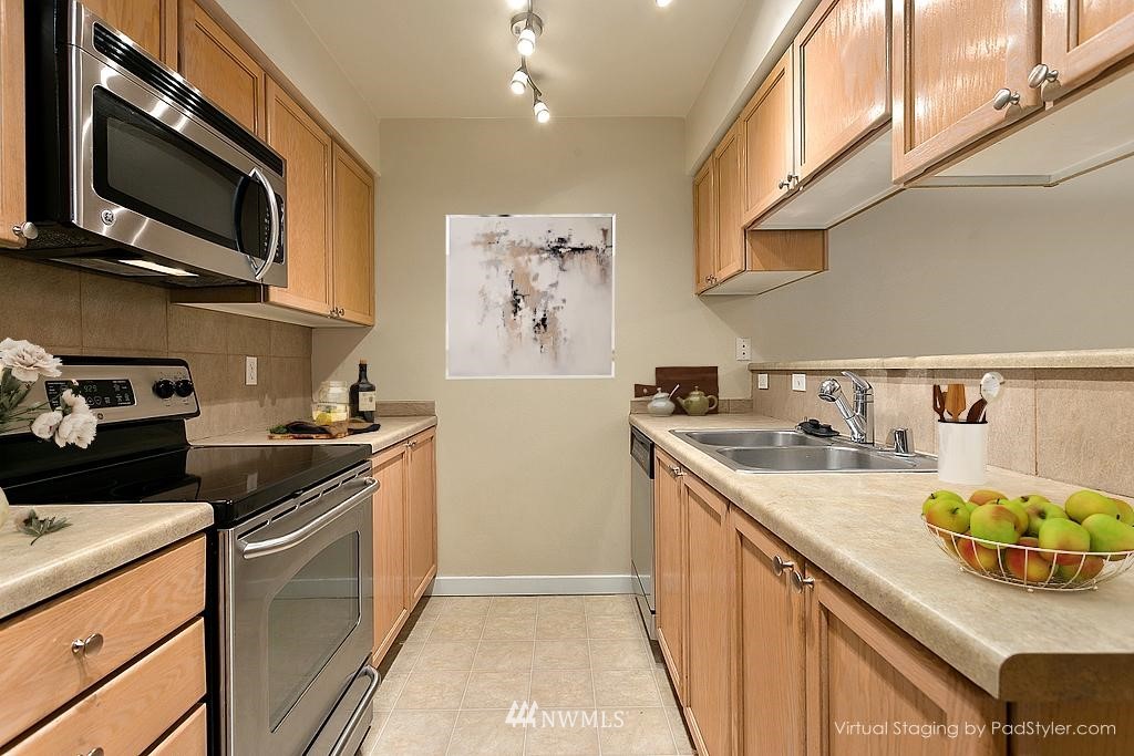18930 Bothell Everett Highway, Unit C303 Bothell, WA 98012 - Photo 6 of 12 a kitchen with stainless steel appliances granite countertop a sink and stove top oven