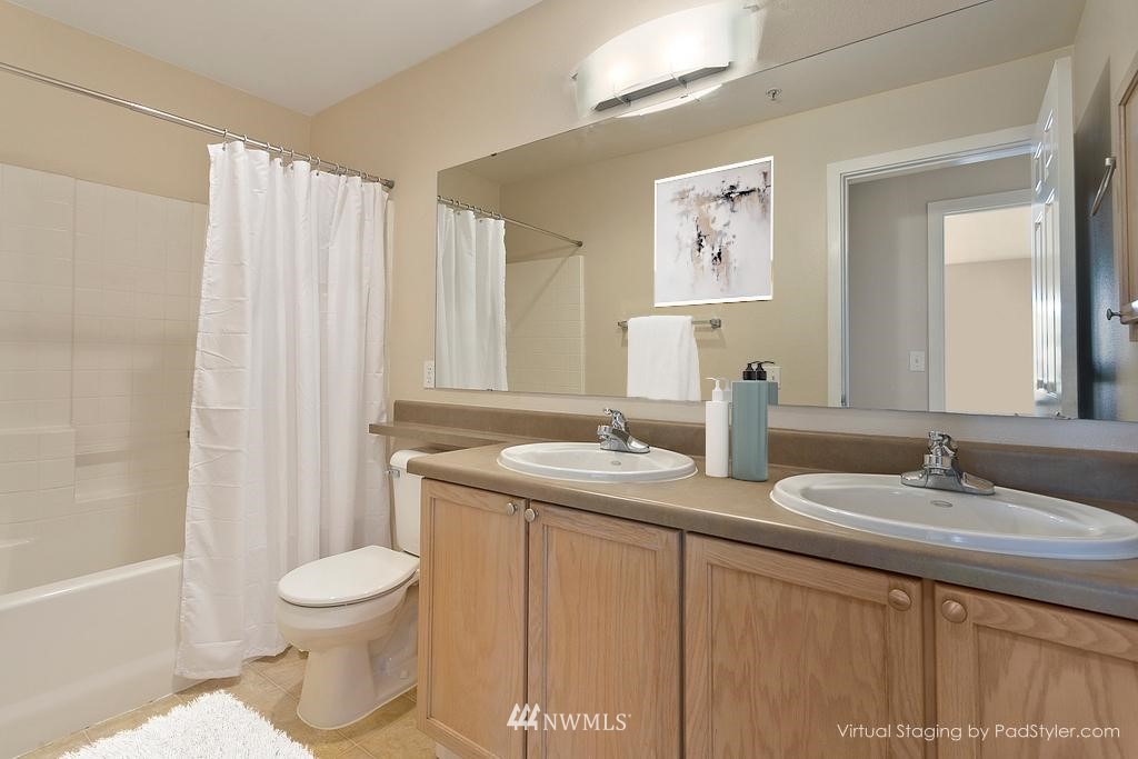 18930 Bothell Everett Highway, Unit C303 Bothell, WA 98012 - Photo 10 of 12 a bathroom with a toilet sink and mirror