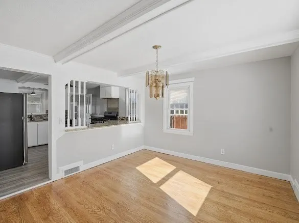 a view of a kitchen with a sink refrigerator and wooden floor