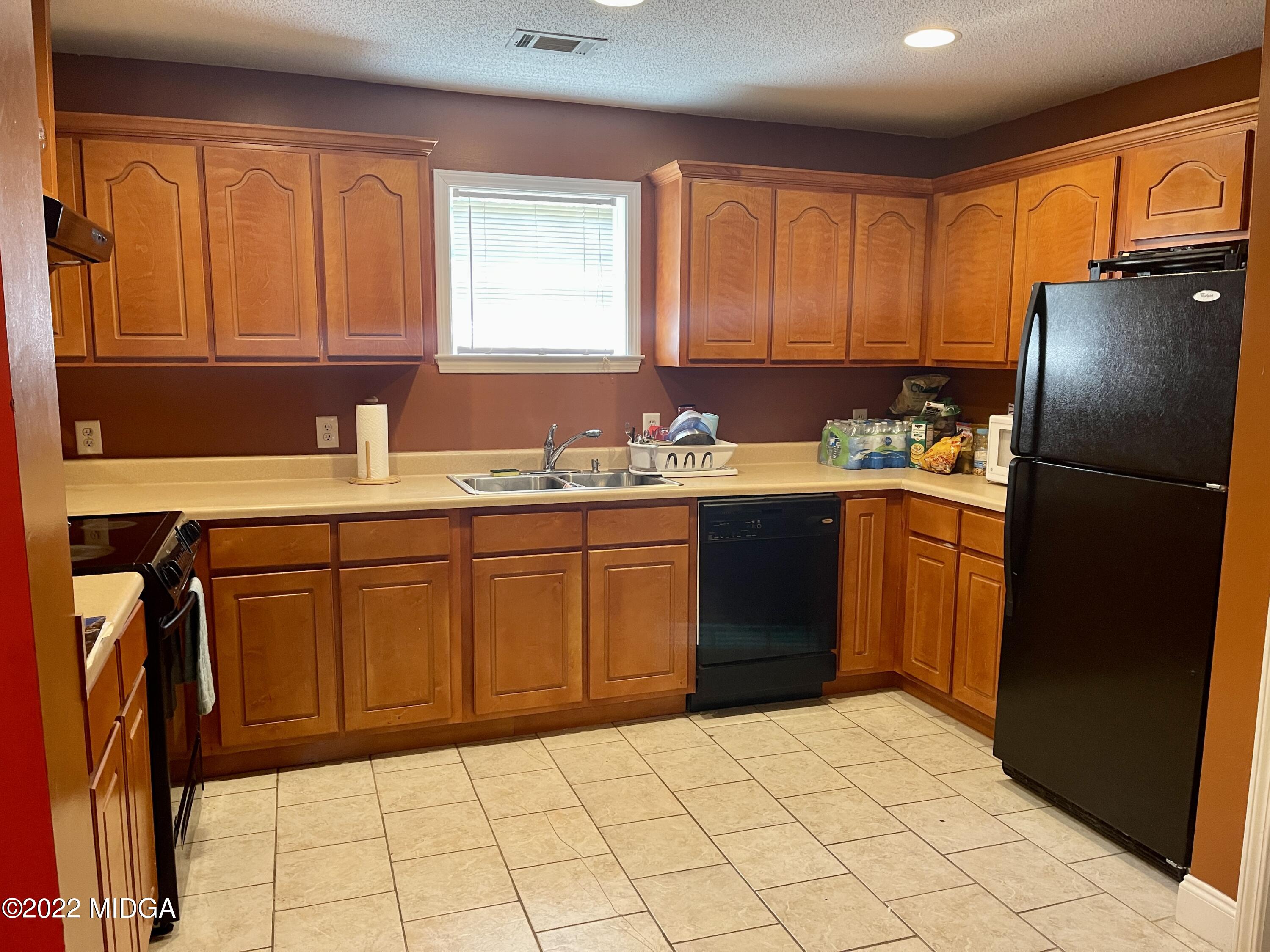 105 Carrs Station Road Sparta, GA 31087 - Photo 6 of 21 a kitchen with a refrigerator sink and cabinets