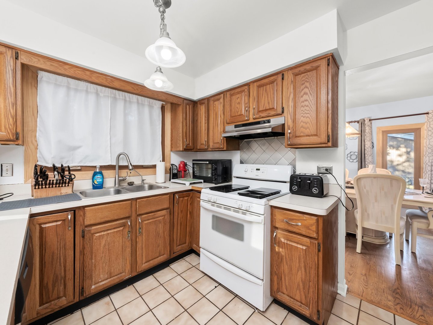 3604 Tee Court North Crete, IL 60417 - Photo 17 of 37 a kitchen with stainless steel appliances granite countertop a sink a stove cabinets dining table and chairs
