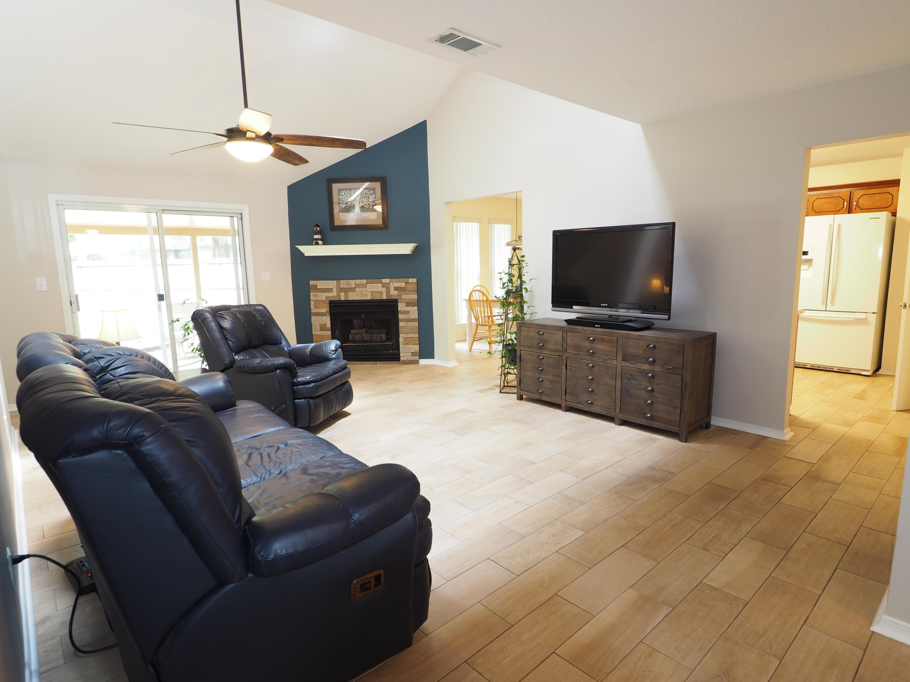 2803 Ram Lane Crestview, FL 32539 - Photo 3 of 35 a living room with furniture a flat screen tv and a fireplace