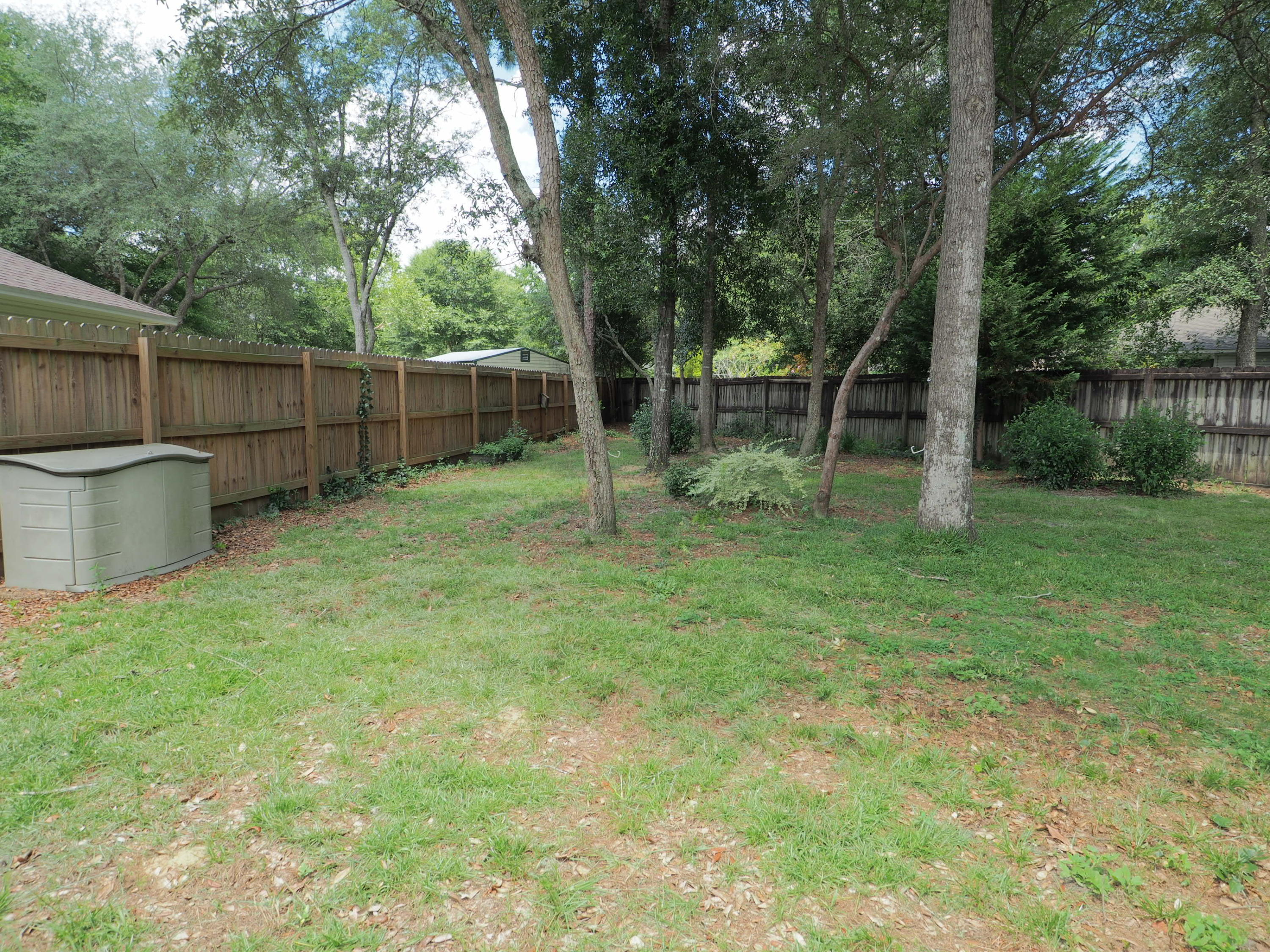 2803 Ram Lane Crestview, FL 32539 - Photo 32 of 35 a backyard of a house with plants and wooden fence
