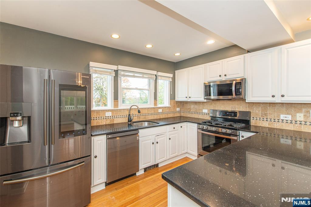 73 Grove Street Clifton, NJ 07013 - Photo 12 of 49 a kitchen with stainless steel appliances granite countertop a stove a sink and a refrigerator