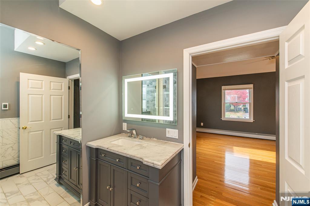 73 Grove Street Clifton, NJ 07013 - Photo 21 of 49 a bathroom with a granite countertop sink and a mirror