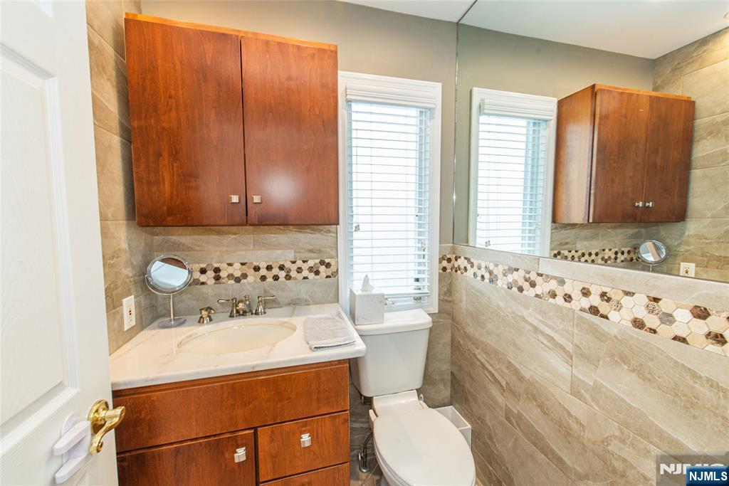 73 Grove Street Clifton, NJ 07013 - Photo 31 of 49 a bathroom with a sink toilet and mirror