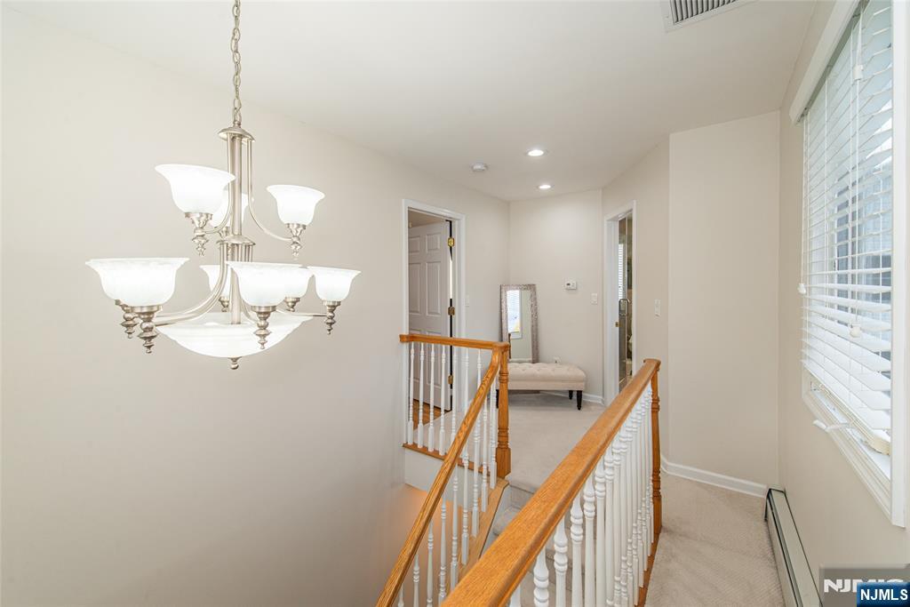 73 Grove Street Clifton, NJ 07013 - Photo 45 of 49 a view of a hallway with a chandelier