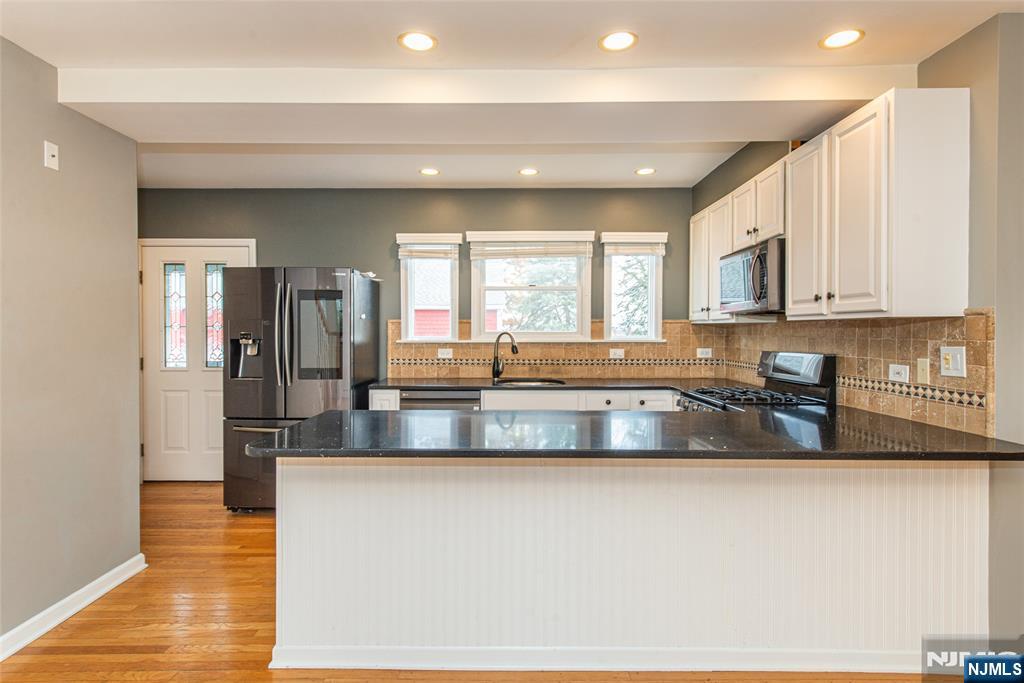 73 Grove Street Clifton, NJ 07013 - Photo 9 of 49 a large kitchen with granite countertop a large window and stainless steel appliances