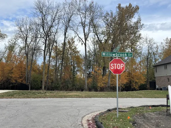 a red sign board with tall trees