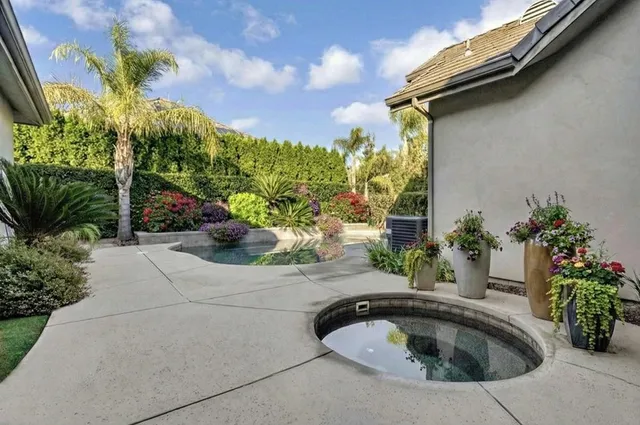 a view of a white house with a yard and potted plants