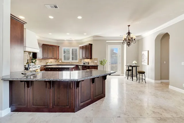 a kitchen with stainless steel appliances granite countertop sink stove top oven and refrigerator