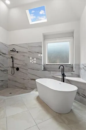 a white bath tub sitting in a bathroom and shower