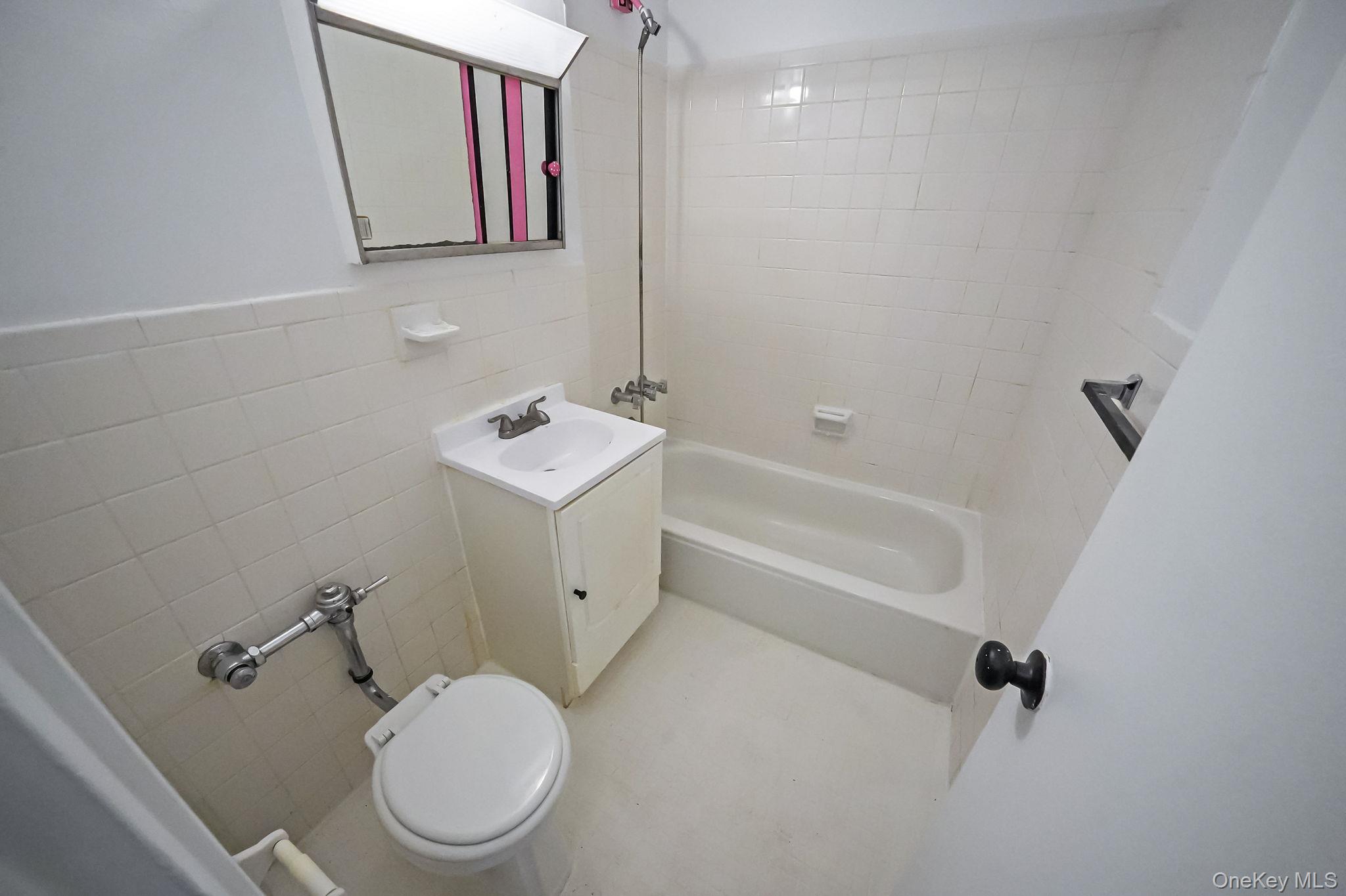 67-50 Thornton Place, Unit 4U Queens, NY 11375 - Photo 13 of 19 Bathroom featuring tile walls, shower combination, and vanity